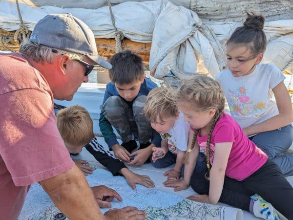 Sailor For A Day Program aboard the A.J. Meerwald.MP Volunteer teaching kids how to navigate using a map aboard the historic A.J. Meerwald during the Sailor For A Day youth sailing program.